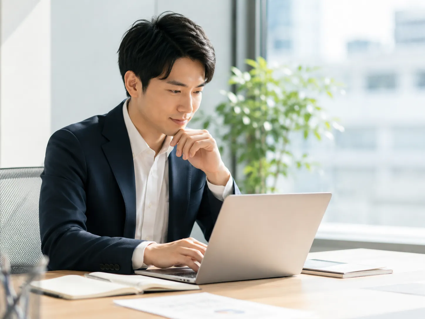 ノートPCを見ながらAI検索や情報整理を行うビジネスマン