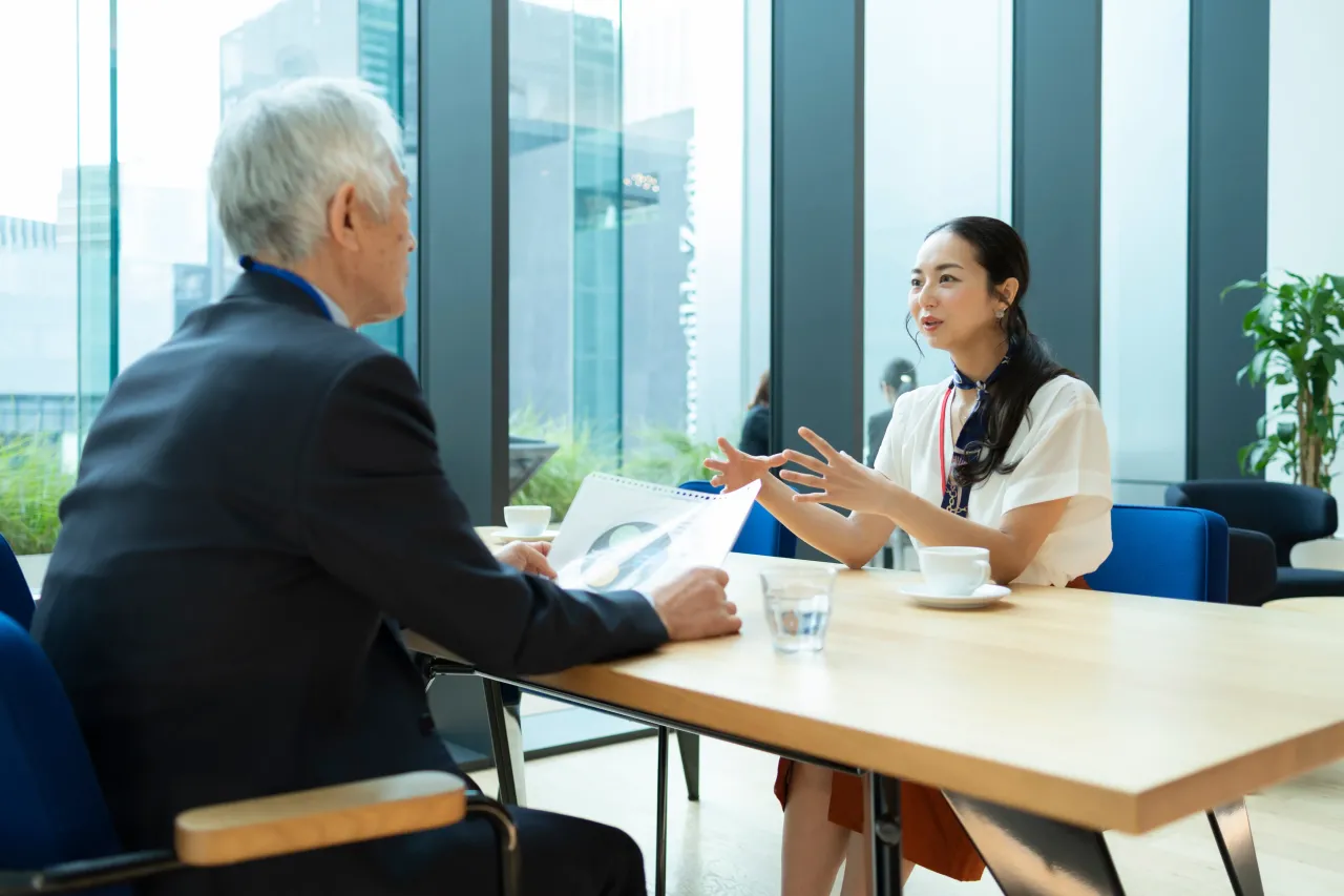 お客様に資料を示しながら提案するスタッフ